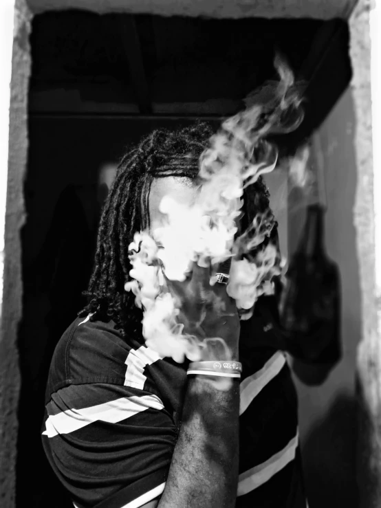 a black and white photo of a man smoking a cigarette, by Daniel Lieske, chief keef, portait image