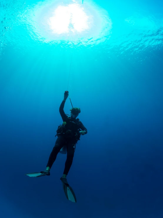 a person on a diving board in the water, standing under the sea, up close, scuba diving, bright deep blue