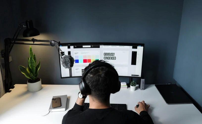 a man sitting at a desk in front of a computer, a computer rendering, trending on unsplash, wearing black headphones, 9 9 designs, white and black color palette, youtube thumbnail