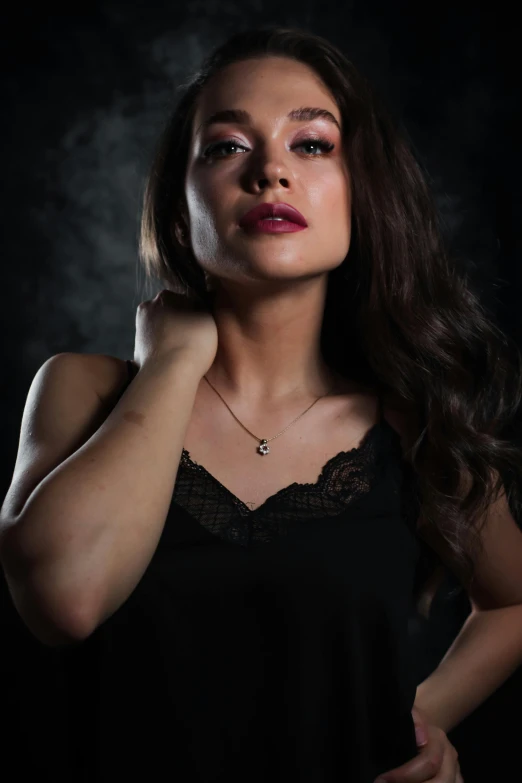 a woman in a black dress posing for a picture, inspired by Elsa Bleda, small necklace, dim studio lighting, 🤤 girl portrait, portrait of vanessa morgan