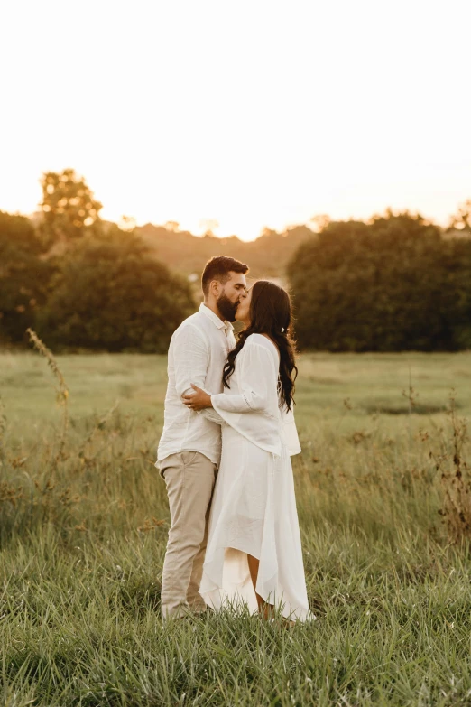 a man and woman standing next to each other in a field, pexels contest winner, couple kissing, white, hispanic, lightly dressed