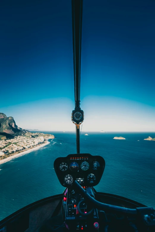 a view from the cockpit of a helicopter over the ocean, by Tobias Stimmer, pexels contest winner, rio de janeiro, clear blue skies, dials, high quality photo