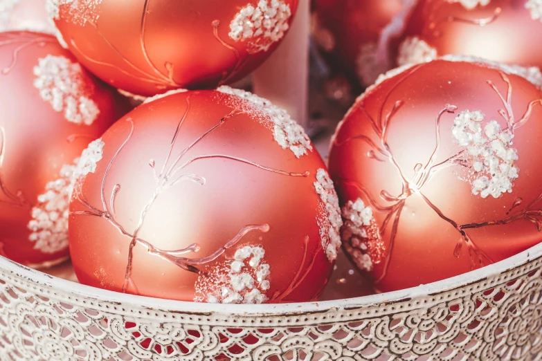 a bowl filled with red ornaments on top of a table, by Zofia Stryjenska, pexels, globes, close up details, thumbnail, blushing