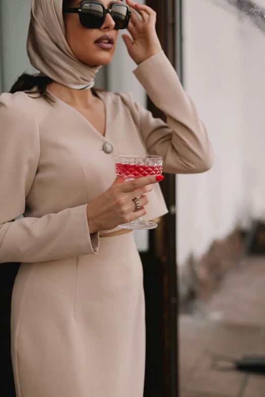 a woman in a beige dress talking on a cell phone, trending on pexels, renaissance, drinking cough syrup, wearing a pink tux, glass ball at the waist, tailored clothing