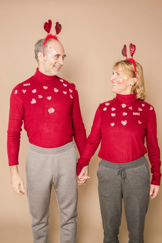 a man and a woman standing next to each other, by Valentine Hugo, trending on pexels, antipodeans, wearing festive clothing, carole feuerman, hearts, wearing turtleneck