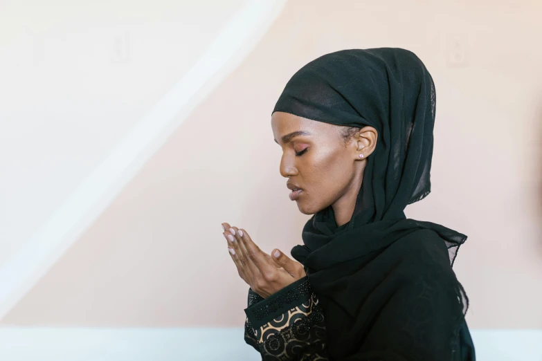 a woman in a black hijab is praying, trending on unsplash, hurufiyya, somali attire, diverse, ashteroth, light skin