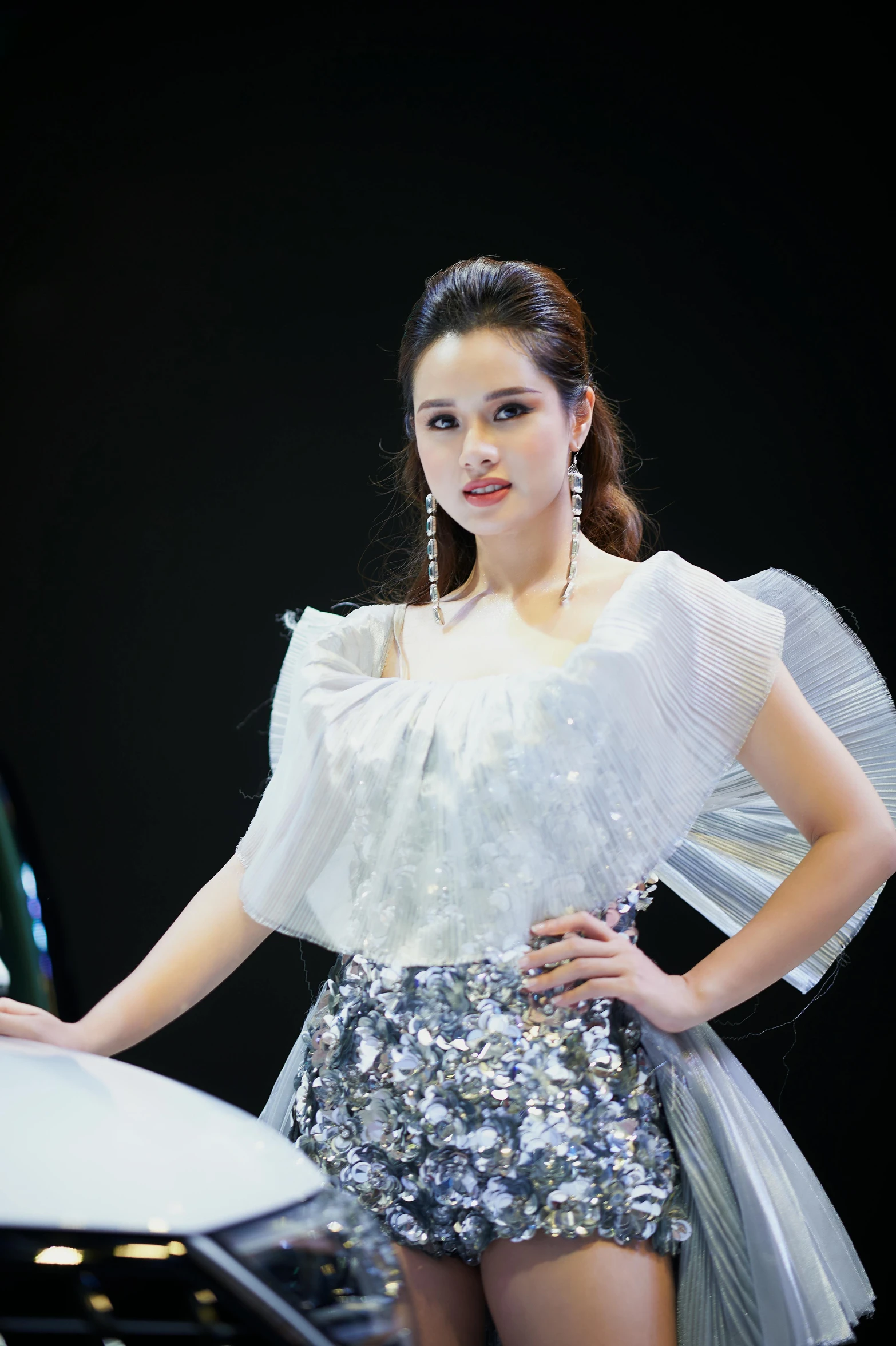 a woman that is standing next to a car, an album cover, by Ruth Jên, happening, wearing silver dress, fashion show, 15081959 21121991 01012000 4k, jamie chung