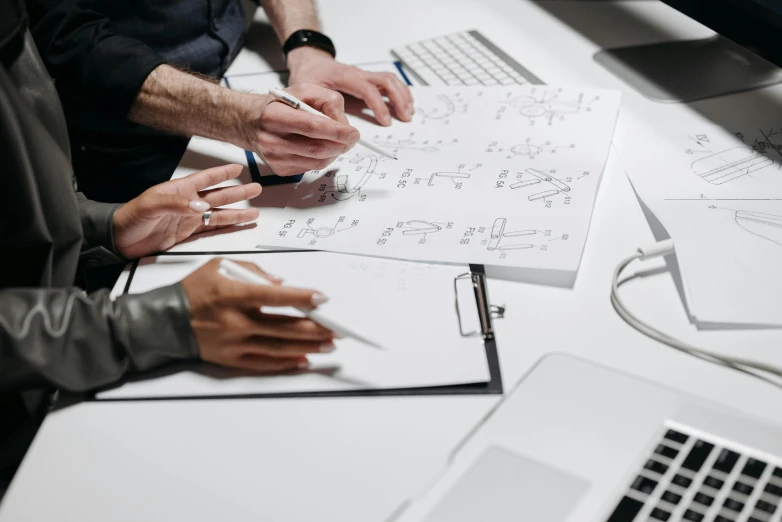 a group of people sitting at a table with laptops, a drawing, by Adam Marczyński, trending on pexels, equations, detailed mechanical hands, on white paper, designer product