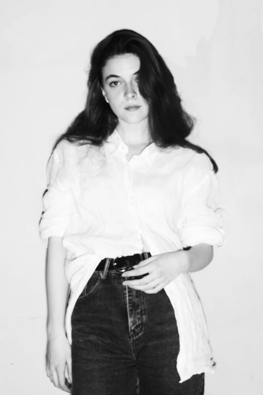 a black and white photo of a woman holding a camera, a black and white photo, by Clifford Ross, tumblr, lorde, wearing a white button up shirt, arab young monica belluci, as fashion editorial 90s