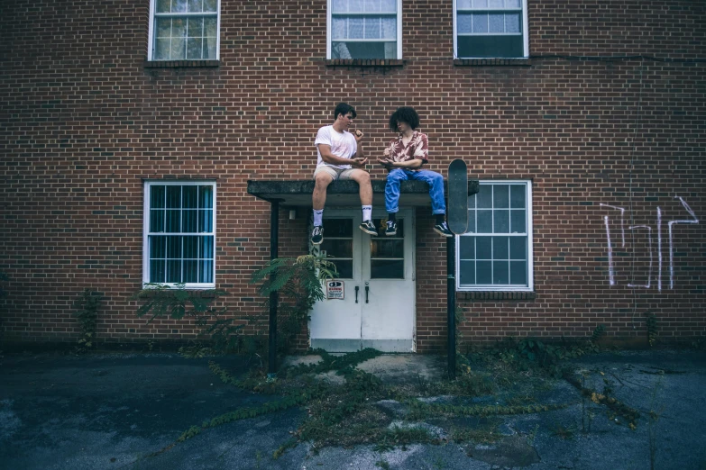 a couple of kids sitting on top of a building, by Carey Morris, pexels contest winner, ashcan school, in an american suburb, brick building, porches, 90s photo