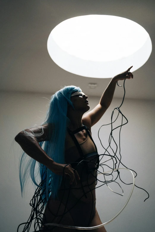 a woman with blue hair holding a light above her head, inspired by Bruce Nauman, unsplash, conceptual art, cables on her body, pvc poseable, long cyan hair, cloud goddess