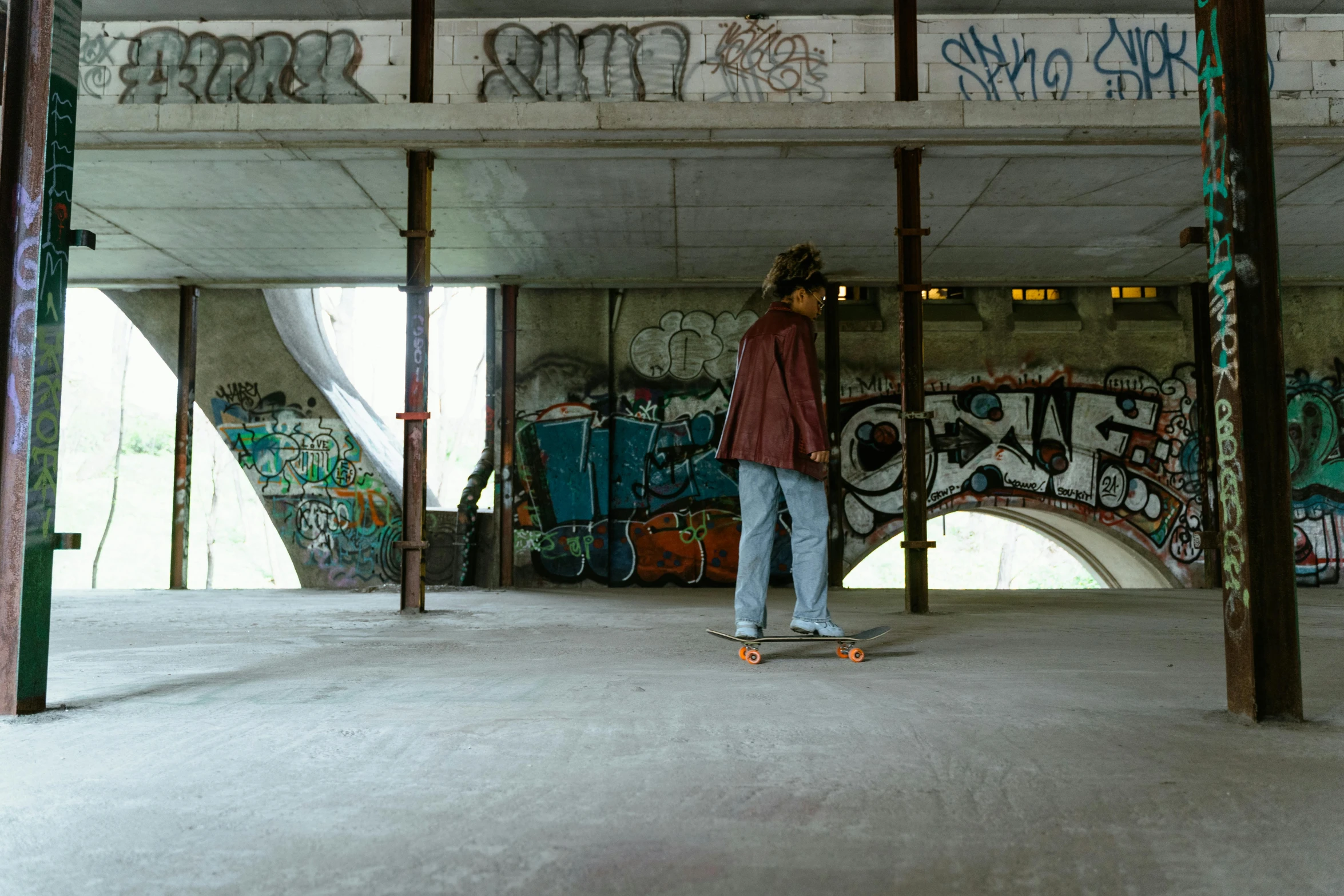 a man riding a skateboard under a bridge, by Jan Tengnagel, unsplash contest winner, graffiti, an empty brutalist chamber, panoramic view of girl, distant full body view, an abandoned old