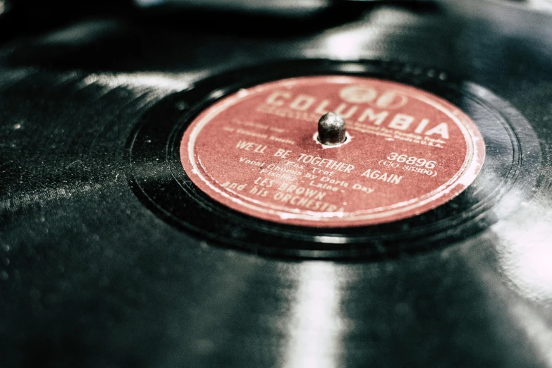 a record sitting on top of a table, an album cover, pexels, 1930s photograph, concert, thumbnail, brown