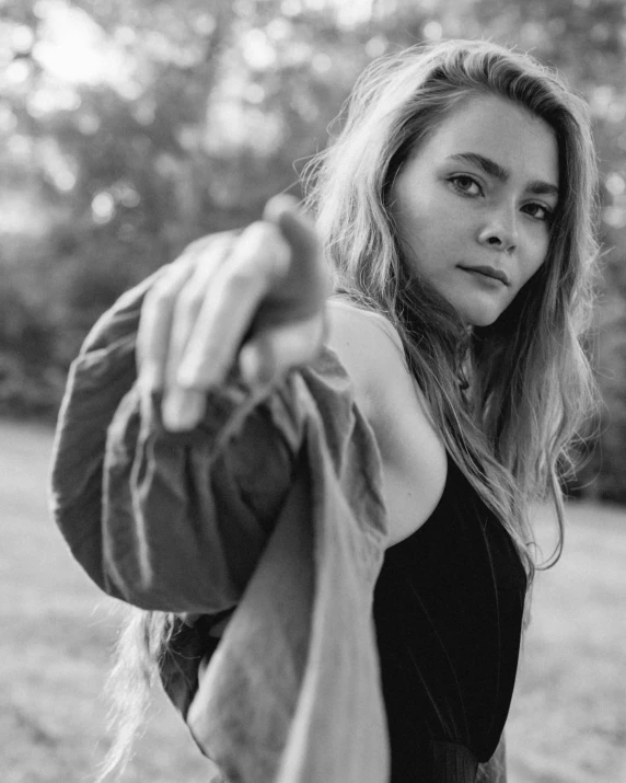 a black and white photo of a woman pointing at the camera, by Emma Andijewska, unsplash, realism, elle fanning, attractive girl, g cgsociety, young southern woman