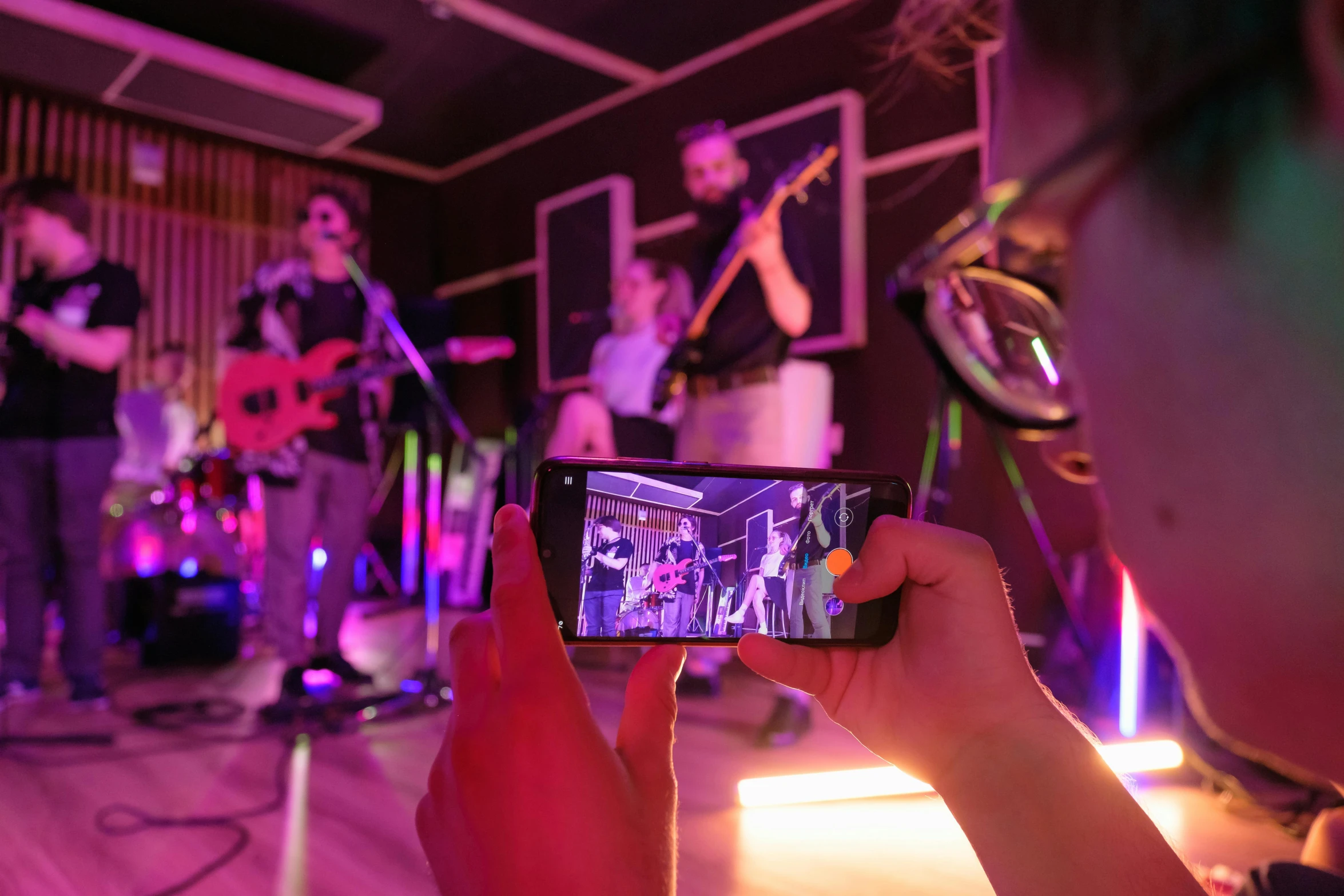 a person taking a picture of a band on a cell phone, night clubs and neons, avatar image, playing guitar onstage, profile image