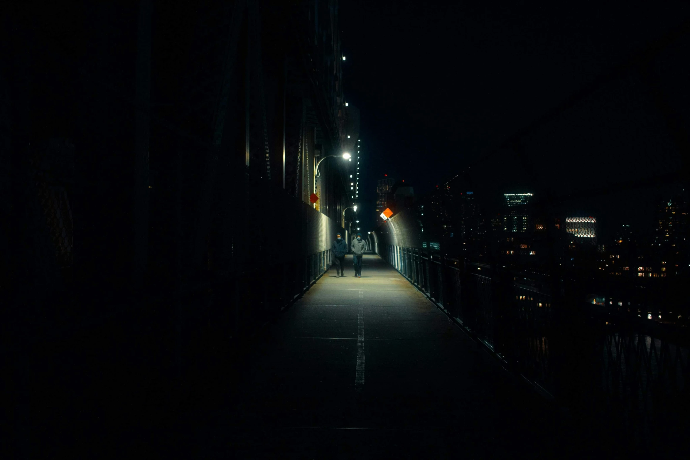 a person walking across a bridge at night, inspired by Elsa Bleda, realism, dark hallways, night city, instagram post, dramatic lighting - n 9