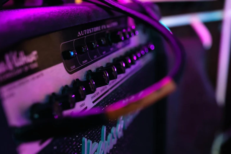 a close up of a guitar amp in a room, a picture, by Robbie Trevino, unsplash, violet and aqua neon lights, show from below, vollumetric lighting, cable plugged into cyberdeck