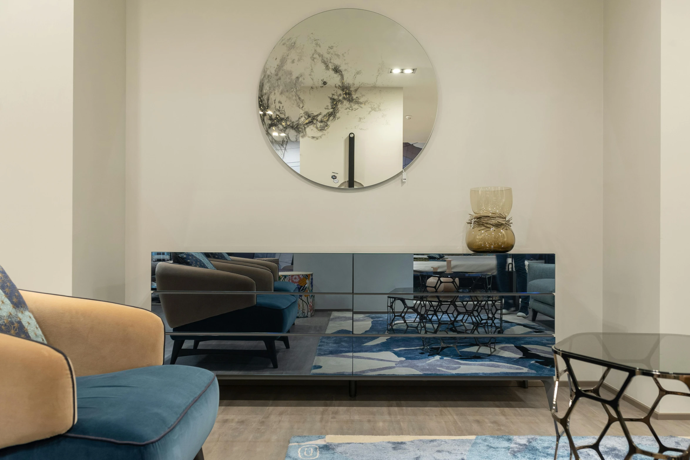 a living room filled with furniture and a round mirror, inspired by Emilio Grau Sala, pexels contest winner, silver and blue color schemes, alfio presotto, gallery display photograph, console