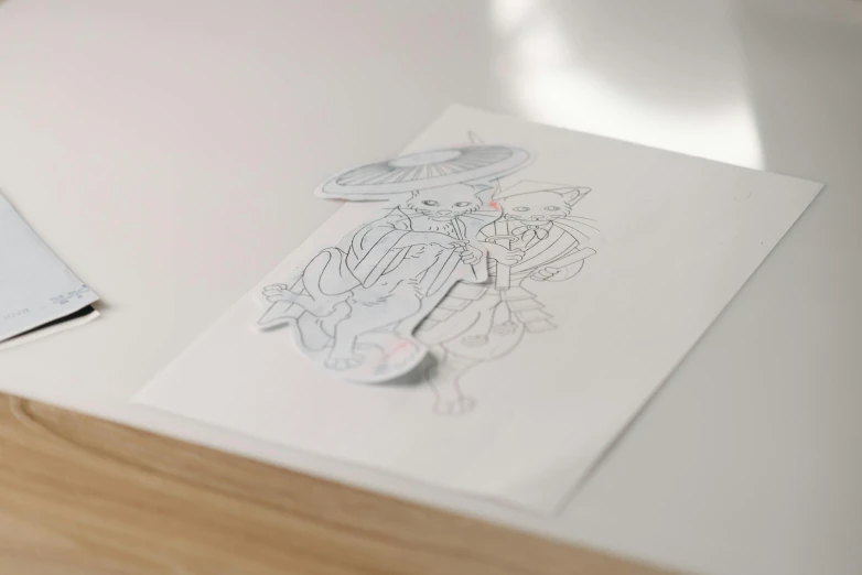 a piece of paper sitting on top of a table, a detailed drawing, inspired by NEVERCREW, fantasy sticker illustration, high quality sketch, on vellum, 3d characters