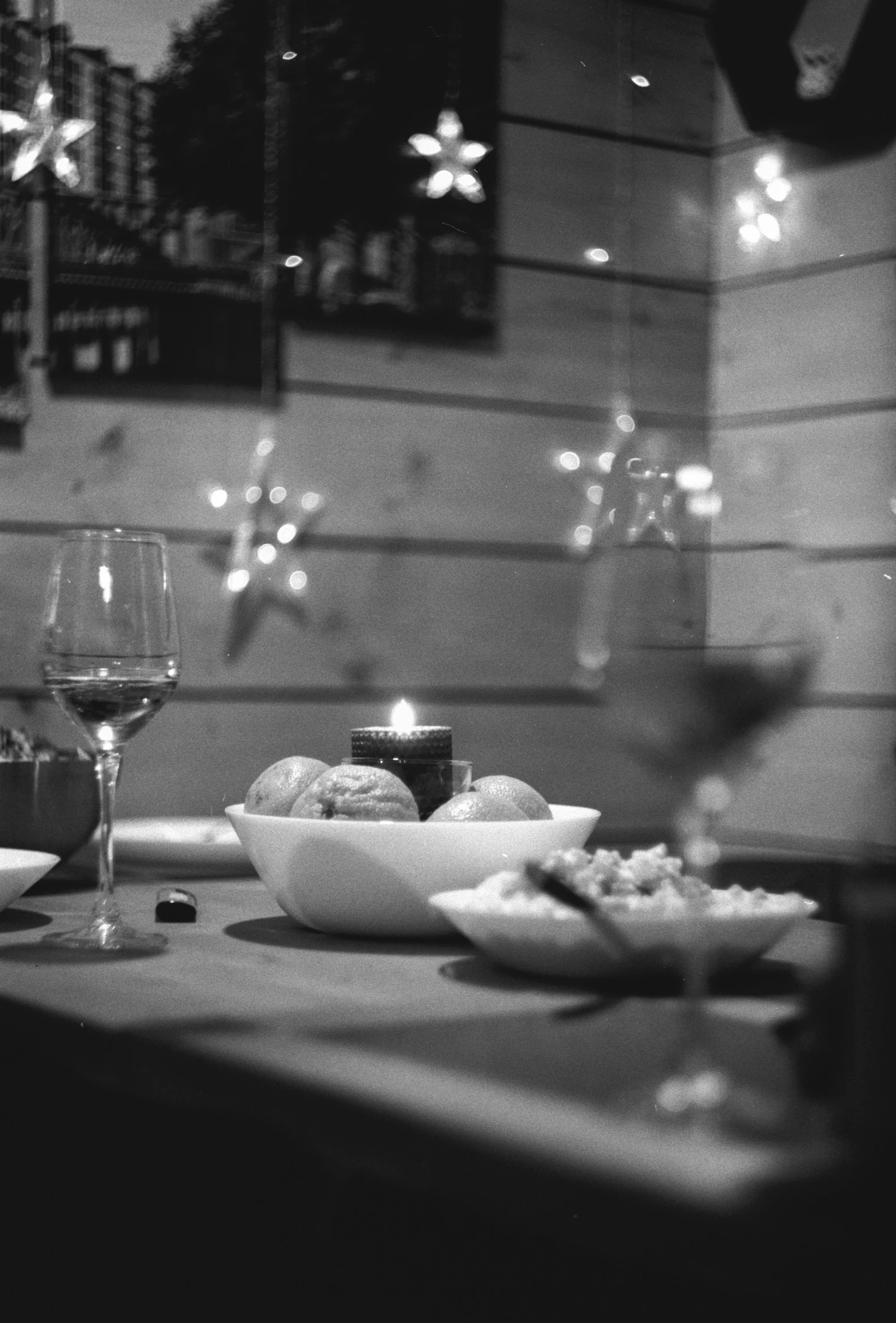 a table topped with plates of food and glasses of wine, a black and white photo, flickr, \!cinestill 50d! film photo, christmas night, pleasant cozy atmosphere, chilling
