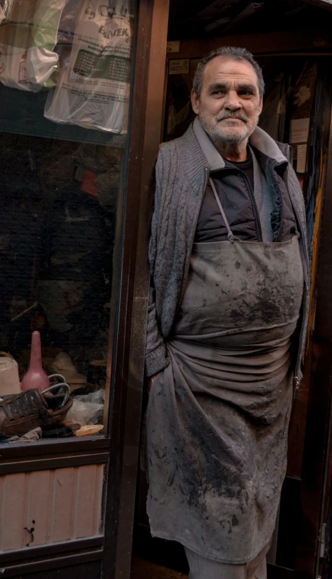 a man that is standing in front of a door, a portrait, by William Berra, pexels contest winner, arte povera, wearing an apron, raku, humans of new york, 15081959 21121991 01012000 4k