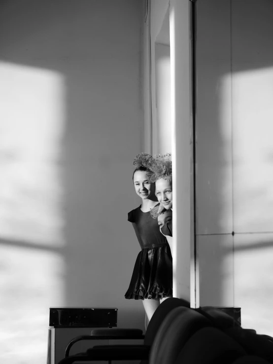 a woman taking a picture of herself in a mirror, a black and white photo, by Emma Andijewska, conceptual art, julia garner, both smiling for the camera, dancers, leaning on door