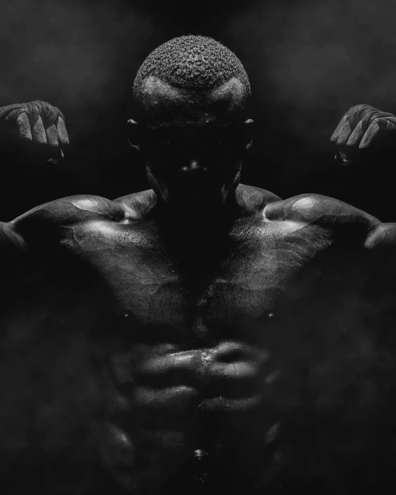 a man flexing his muscles in the dark, a black and white photo, pexels contest winner, realism, black man, muscled humanoid balrog demon, [ adamantly defined abs ]!!, 6 pack