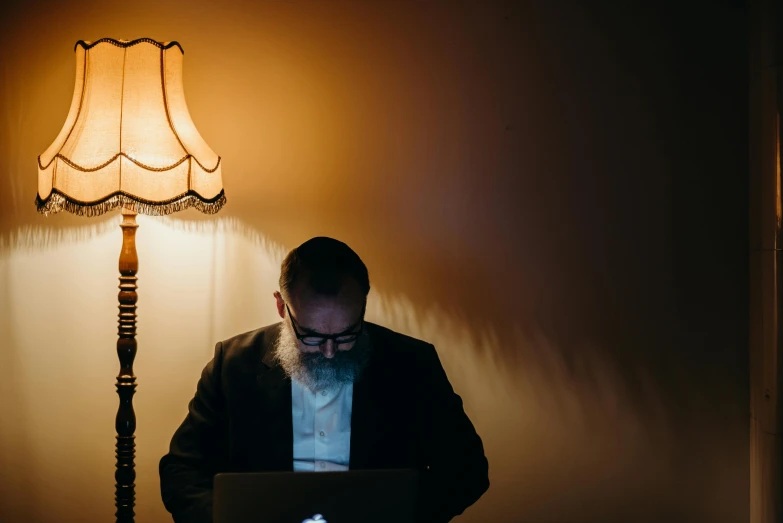 a man sitting in front of a laptop computer, by Matt Cavotta, unsplash, renaissance, emerging from a lamp, light beard, ignant, orthodox