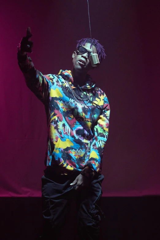 a man standing on top of a stage holding a microphone, an album cover, pexels, visual art, 2 1 savage, he wears an eyepatch, purple haze, ( ( theatrical ) )