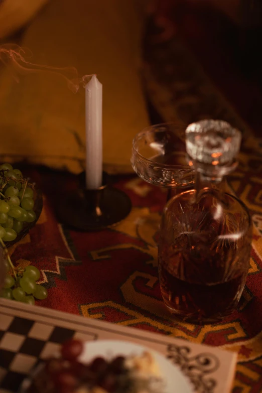 a close up of a plate of food on a table, inspired by Georges de La Tour, renaissance, glass with rum, grape, ayahuasca, ambient amber light