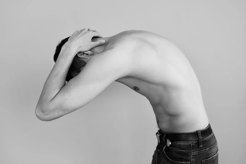 a black and white photo of a shirtless man, a black and white photo, pexels, figuration libre, bent over posture, facepalm, non binary model, various posed