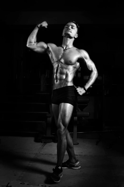 a man flexing his muscles in the dark, a black and white photo, inspired by Peter Basch, bodybuilder ernest khalimov, dark taint :: athletic, female model, made of flesh and muscles