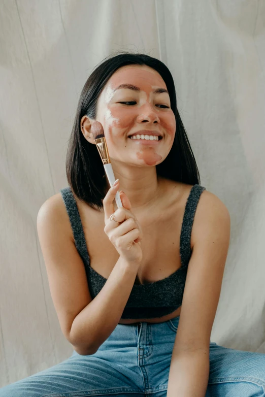 a woman sitting on a bed brushing her teeth, by Julia Pishtar, trending on pexels, happening, asian face, textured base ; product photos, smiling mask, silicone skin