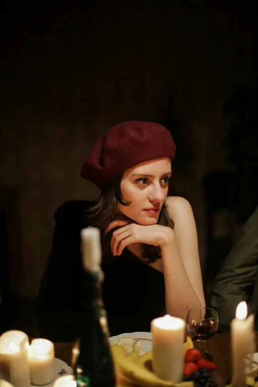 a woman sitting at a table with candles in front of her, inspired by Elsa Bleda, pexels, renaissance, wearing a french beret, velvet, having an awkward dinner date, woman model