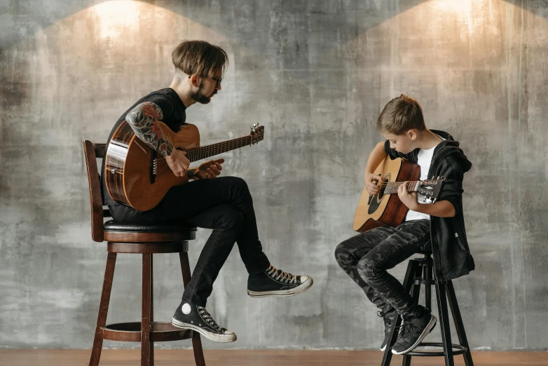 a man and a woman sitting on stools playing guitars, pexels contest winner, cute boys, two buddies sitting in a room, profile pic, kid a