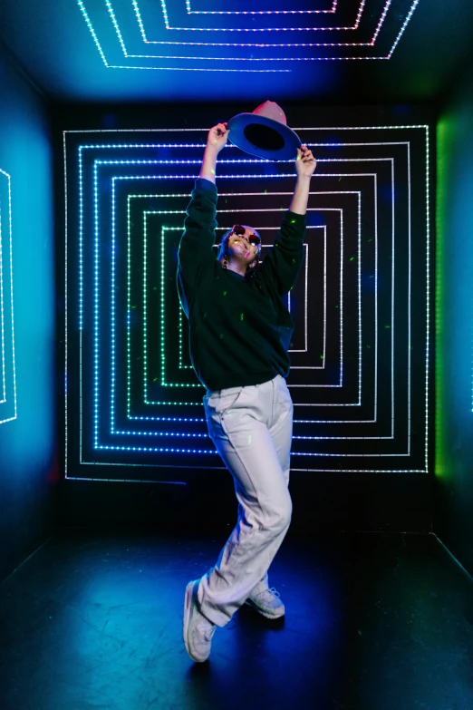 a man standing in a room with a frisbee in his hand, a hologram, inspired by David LaChapelle, pexels contest winner, playful pose, maze, bad bunny, ring lighting