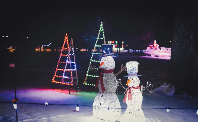 a couple of snowmen that are standing in the snow, pexels, visual art, neon lights lots of trees, outdoor fairgrounds, winter lake setting, rectangle