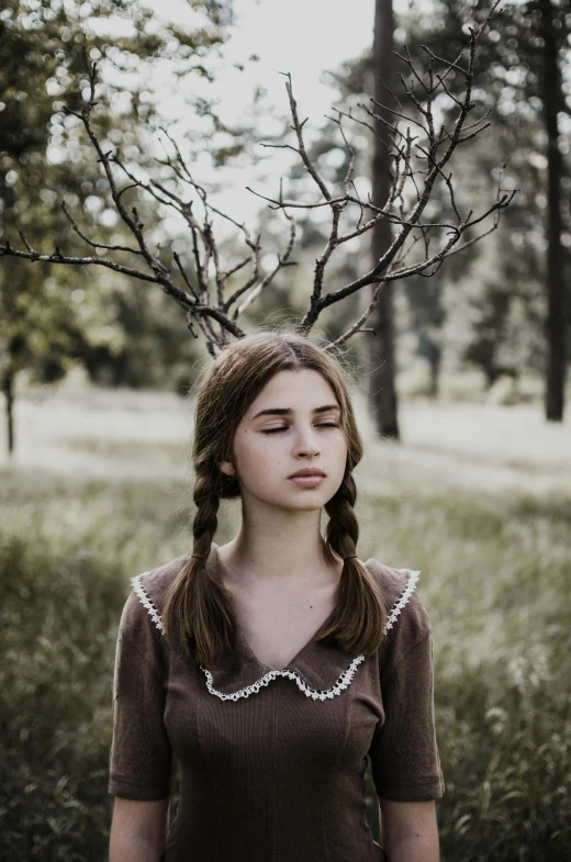 a woman standing in a field with a tree on her head, an album cover, inspired by Elsa Bleda, pexels contest winner, renaissance, two pigtails hairstyle, portrait of a young teenage girl, the antler people, 🤤 girl portrait