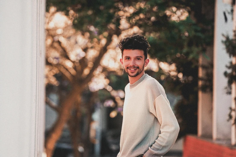 a man that is standing on a skateboard, by Niko Henrichon, pexels contest winner, portrait of a smiling, he is wearing a brown sweater, brandon woelfel, an all white human