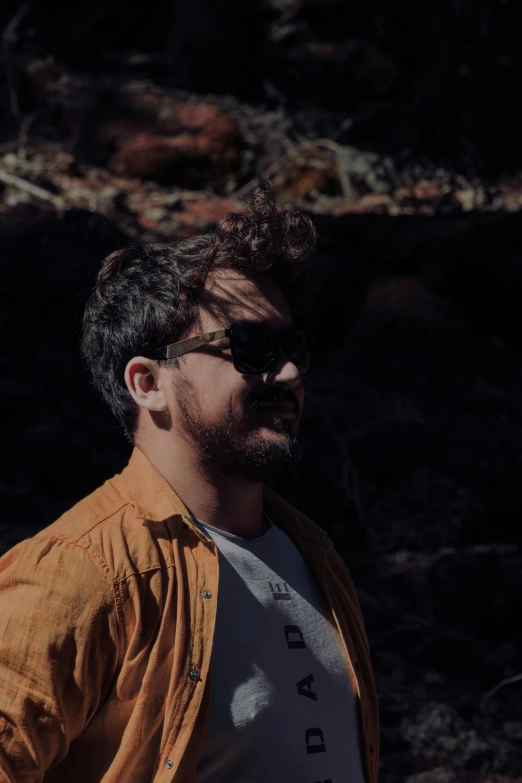 a man standing in the woods with a frisbee, an album cover, inspired by Alexis Grimou, unsplash, happening, with sunglass, aboriginal australian hipster, headshot profile picture, grainy movie still