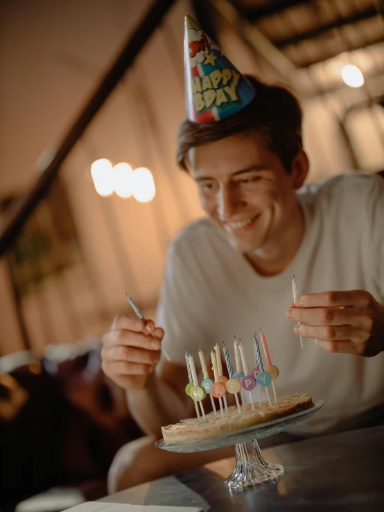 a man sitting at a table with a birthday cake