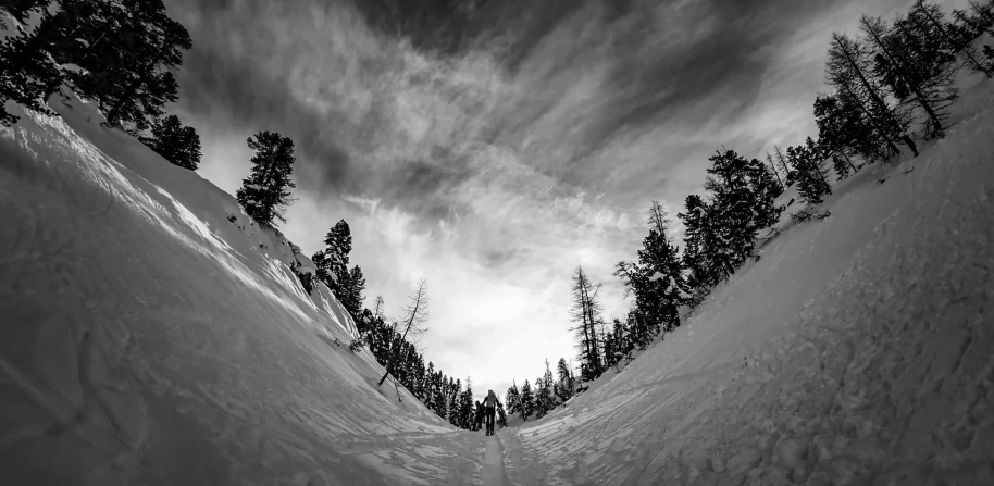 a man riding a snowboard down a snow covered slope, a black and white photo, by Arnie Swekel, unsplash contest winner, epic scale fisheye view, yosemite, epic sky, photograph captured in a forest