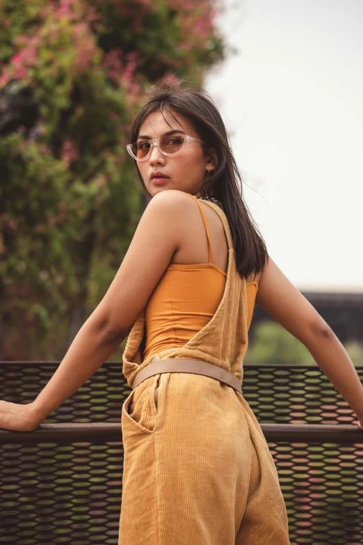 a woman standing on top of a wooden bench, trending on pexels, wearing yellow croptop, overalls, shades of gold display naturally, asian woman