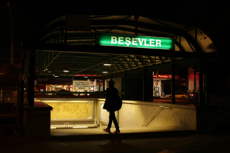 a person standing in front of a bus stop at night, an album cover, by David Brewster, berlin secession, beaver, mta subway entrance, the riddler, terminal