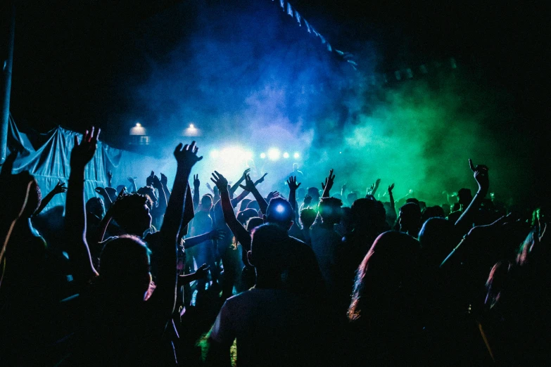a crowd of people at a concert with their hands in the air, pexels contest winner, happening, black light rave, photograph of three ravers, smoke grenades, party at midnight