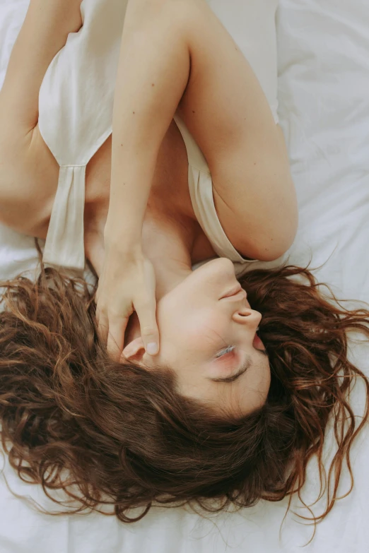 a beautiful young woman laying on top of a bed, inspired by Elsa Bleda, trending on pexels, renaissance, hair flowing down, gif, soft lulling tongue, ignant