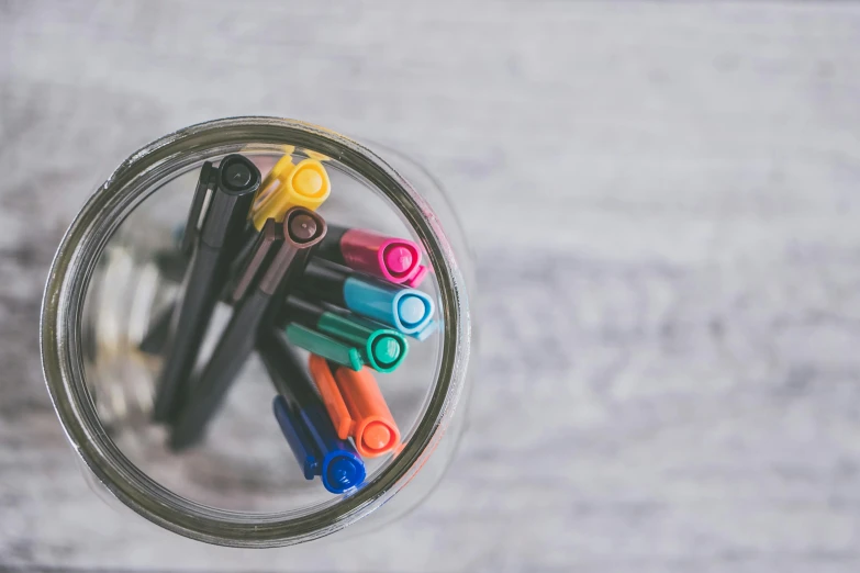 a jar filled with markers and pens on top of a wooden table, pexels, fan favorite, circular, thumbnail, fountain pen