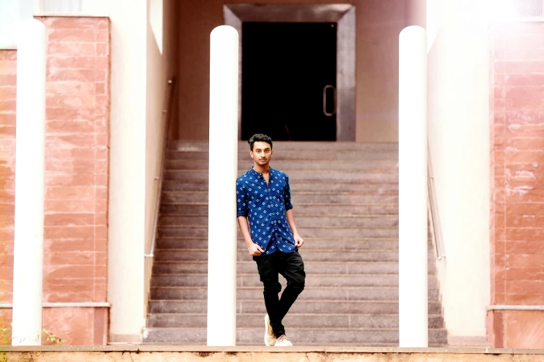 a man standing on the steps of a building, inspired by Ke Jiusi, pexels contest winner, realism, wearing a kurta, full length photo, at college, blue toned