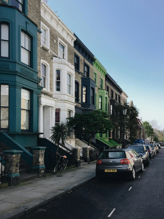 a street filled with lots of parked cars, by Rachel Reckitt, trending on unsplash, victorian house, ignant, profile image, london