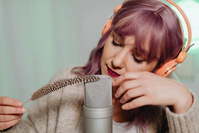 a woman with headphones is singing into a microphone, by Emma Andijewska, trending on pexels, realism, lilac hair, thumbnail, studio recording, cottagecore hippie